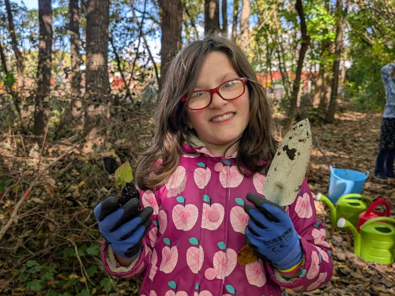 posing with small tree and trowel planting